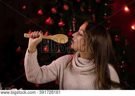 Cute Long-haired Brunette Girl Sings Using Wooden Spatula Instead Of Microphone On Background Of Chr