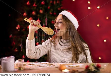 Cute Long-haired Brunette Girl In Santa Hat Sings Using Wooden Spatula Instead Of Microphone Making 