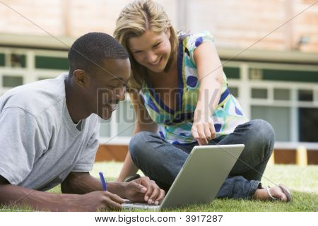 Due studenti all'aperto sul prato con Laptop