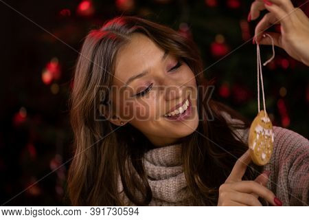 Traditionalist Concept. Cute Smiling Brunette Young Woman Plays With Decorated Christmas Cookies On 