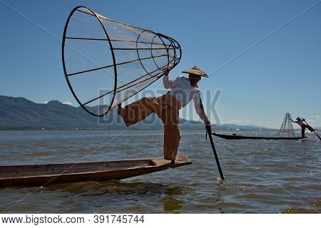 Nanthe. Myanmar. November 27, 2016. Clownfishermen On Inle Lake Pose In Front Of Tourist Photographe