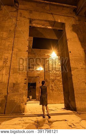 A Young Girl Between The Columns At Night Of The Temple Of Kom Ombo In Traditional Dress, The Temple