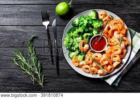 Garlic Butter Prawns Or Shrimps Deshelled And Fried Served With Steamed Broccoli, Ketchup, And Lime 