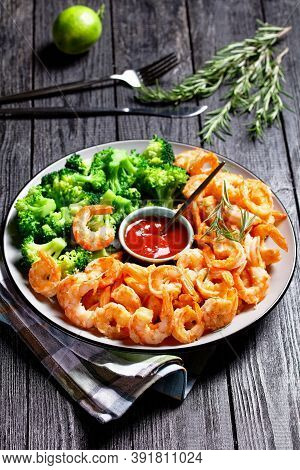 Garlic Butter Prawns Or Shrimps Deshelled And Fried Served With Steamed Broccoli, Ketchup, And Lime 