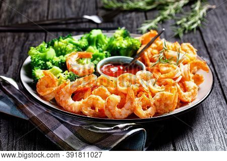 Garlic Butter Prawns Or Shrimps Deshelled And Fried Served With Steamed Broccoli, Ketchup, And Lime 