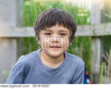 Cute Little Boy Looking At Carema With Smiling Face, Head Shot Of Happy Child Playing Outdoors In Sp