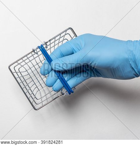 Shopping Metal Empty Basket In Male Hand In Blue Protecive Glove. Shopping During Coronavirus Lockdo