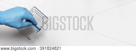 Shopping Metal Empty Basket In Male Hand In Blue Protecive Glove. Shopping During Coronavirus Lockdo