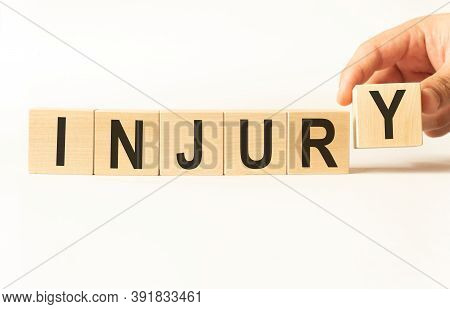 Word Injury. Wooden Small Cubes With Letters Isolated On White Background With Copy Space Available.