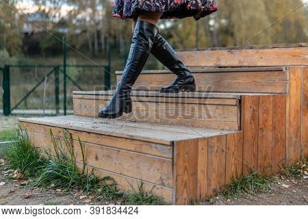 A Cheerful Lady Walks Up The Stairs In A Burgundy Palette And Biret, With A Beautiful Smile In Black