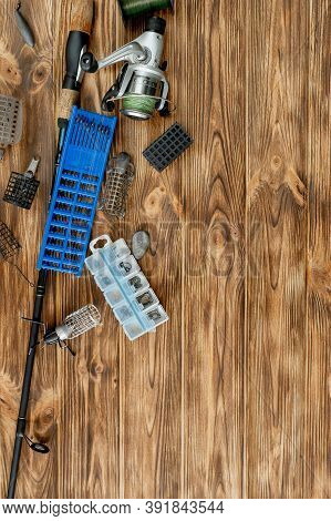 Flat Lay With Fishing Tackle, Fishing Rod And Plastic Box With Fishing Tackle And Hooks, Feeders On 