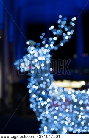 Blurred Lights Of Christmas Installation - Defocused Lights Of Deer On Night City Background. Christ