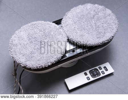 Downside Of Vacuum Cleaner Robot For Washing Glass Window And Remote Control On Grey Background. Rob
