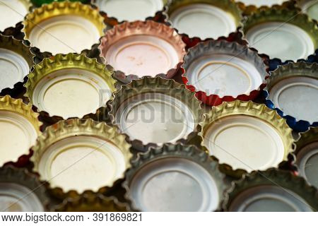 Collection of bottle caps on a stone table.