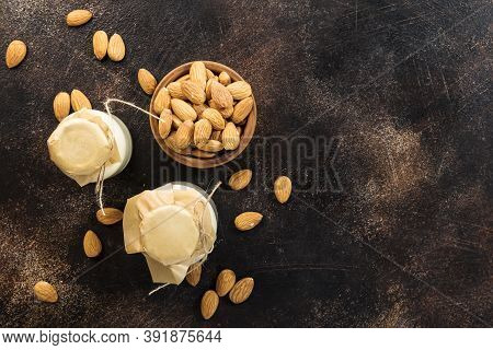 Vegan Almod Milk In Bottles, Closeup, Brown Background. Non Dairy Alternative Milk. Healthy Vegetari