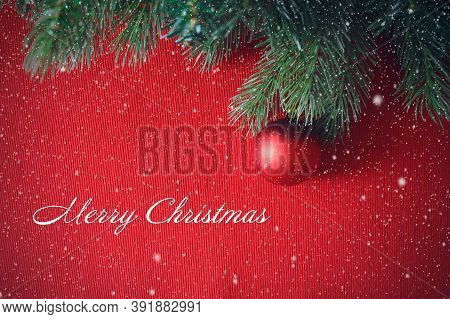 Spruce Green Branches On A Red Background And Red Ball, Christmas Toy. Happy New Year And Merry Chri