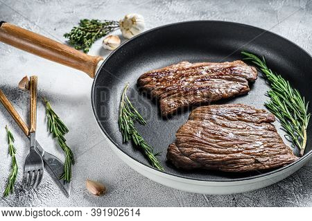 Grilled Flat Iron And Flank Steaks In A Pan. Marble Beef Meat. Gray Background. Top View