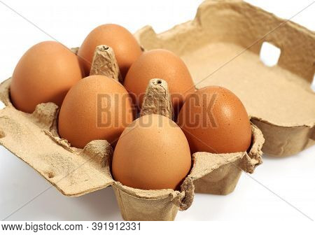Chicken Eggs In Eggbox Against White Background