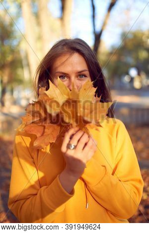 Beautiful Caucasian Young Woman Walking And Having Fun Outdoors In Autumn Time. Bright Yeallow Color