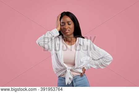 Overworked Black Woman Suffering From Headache On Pink Studio Background. Stressed African American 