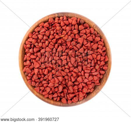 Annatto Seeds In Wooden Bowl, Isolated On White Background. Achiote Seeds, Bixa Orellana. Natural Dy