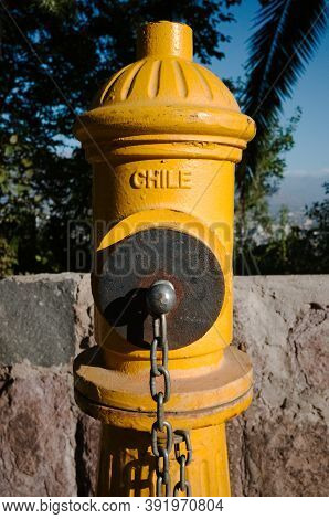 Bright Vibrant Yellow Fire Hydrant Close Up With Word Chile On It. Fireplug Texture Background. Sant