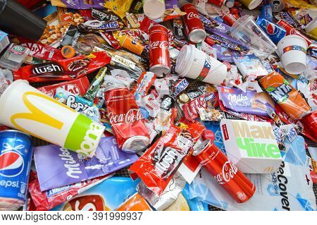 Many Wrappings And Cans From Used Products By Famous Worldwide Brands. Pattern Of Trash Of Various C