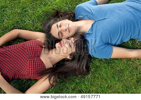Young Couple Taking A Nap On Green Grass