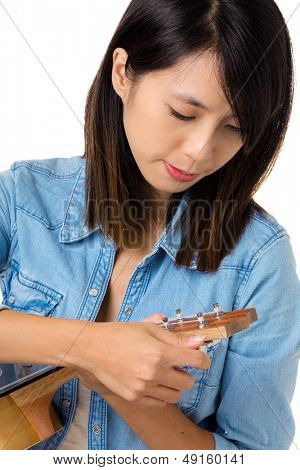 Asiatisk kvinde tunning ukelele