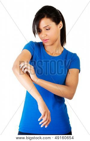 Young woman scratching her self. Isolated on white