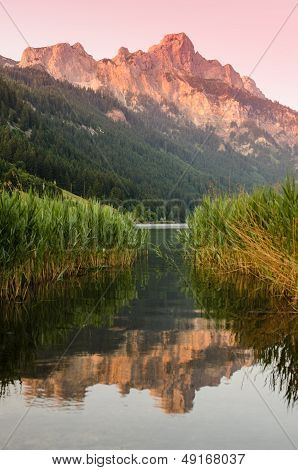 Mountain With Afterglow And Reflection In The Water Of A Lake