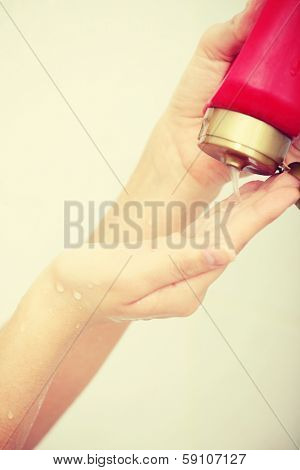 Liquid Gel Soap Pouring from Bottle into a Woman's Hand