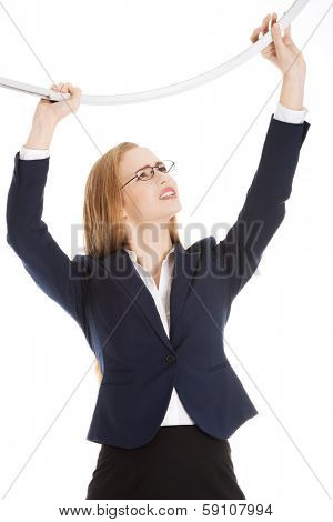 Beautiful business woman holding sth heavy above her. Isolated on white.