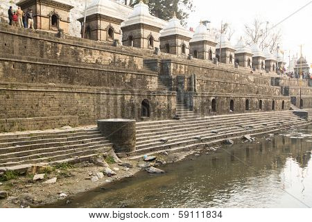 KATHMANDU, NEPAL - DEC 20: During the cremation ceremony along the holy Bagmati River in Bhasmeshvar Ghat at Pashupatinath temple, Dec 20, 2013 in Kathmandu, Nepal.