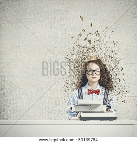 Young funny woman in glasses using typewriter