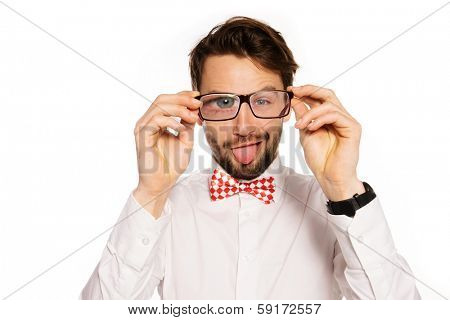 Humorous portrait of a goofy young businessman wearing glasses squinting and sticking out his tongue in a playful gesture, isolated on white