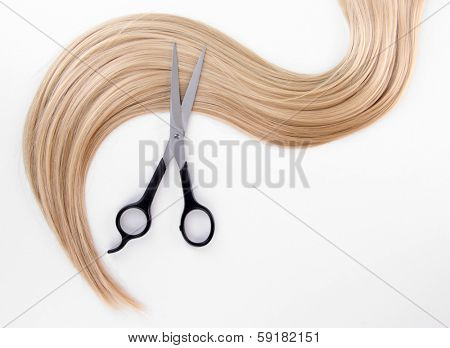 Long blond hair and scissors isolated on white