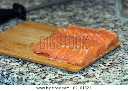Fresh salmon fish with knife on wooden cooking desk