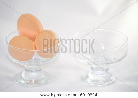 Two bowls one of wich with eggs.