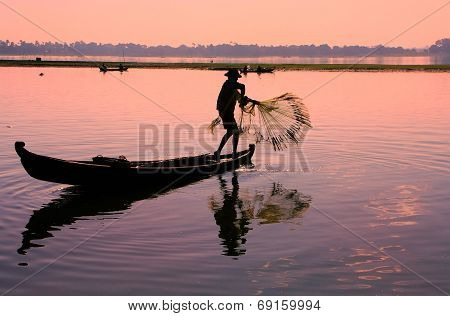 AMARAPURA, MYANMAR - DECEMBER 31: An unidentified man fishes in a lake on December 31, 2011 in Amara