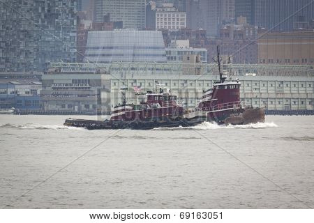 NEW YORK - MAY 27: Tugboats Robert E. McAllister and Resolute trail the USS Oak Hill (LSD 051) after departing Pier 92 at the end of Fleet Week NY. Image contains visible atmospheric distortion. 