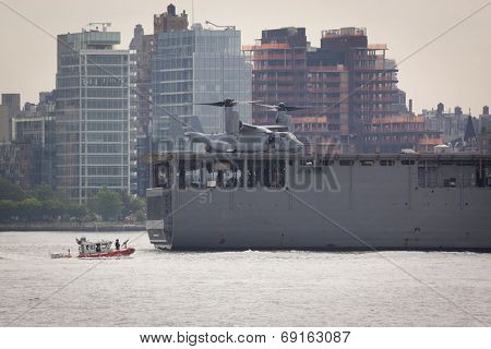 NEW YORK - MAY 27: A US Coast Guard boat runs alongside the stern of the USS Oak Hill (LSD 051) on the Hudson River after departing Pier 92 at the end of Fleet Week NY on May 27, 2014.