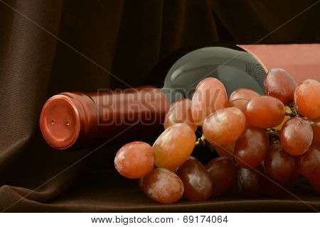 Bottle of red wine and bunch of grapes