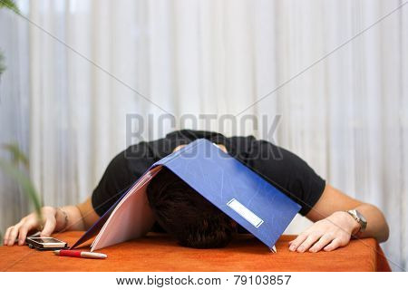 Tired, exhausted or despondent young man with a folder over his head