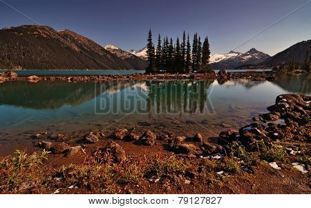 Interesting evergreen trees in a clear mountain lake