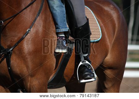 Close Up Of Child And His Mother Sitting On Horse