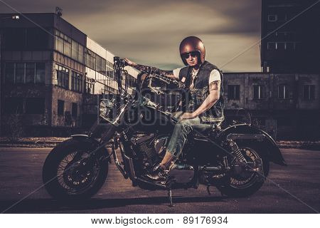Biker and his bobber style motorcycle on a city streets 