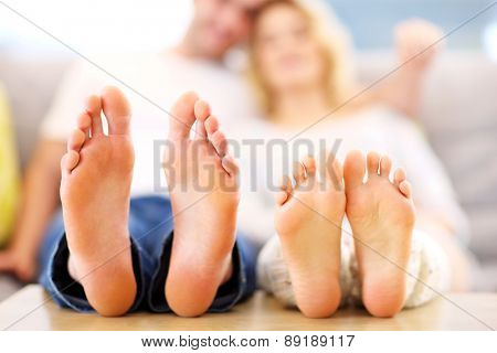 A picture of barefeet couple lying on a sofa