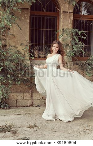Beautiful Young Bride Girl In Wedding Dress With Blowing Chiffon Skirt. Outdoor Portrait. Soft Color