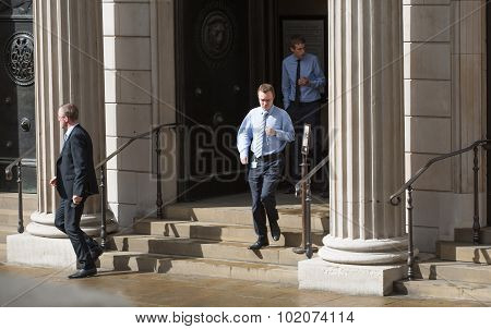 LONDON, UK - SEPTEMBER 17, 2015: Businessmen run out from the Bank of England doors